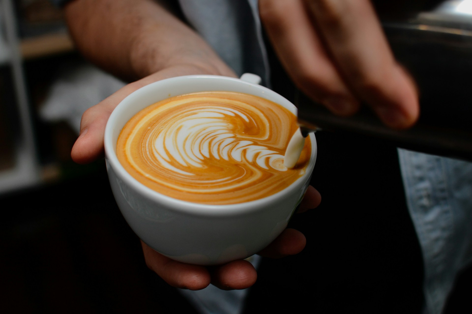 A barista makes coffee art
