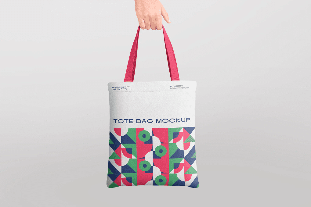 A hand holding canvas tote bag mockup