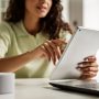 A woman reading iPad and sit near laptop