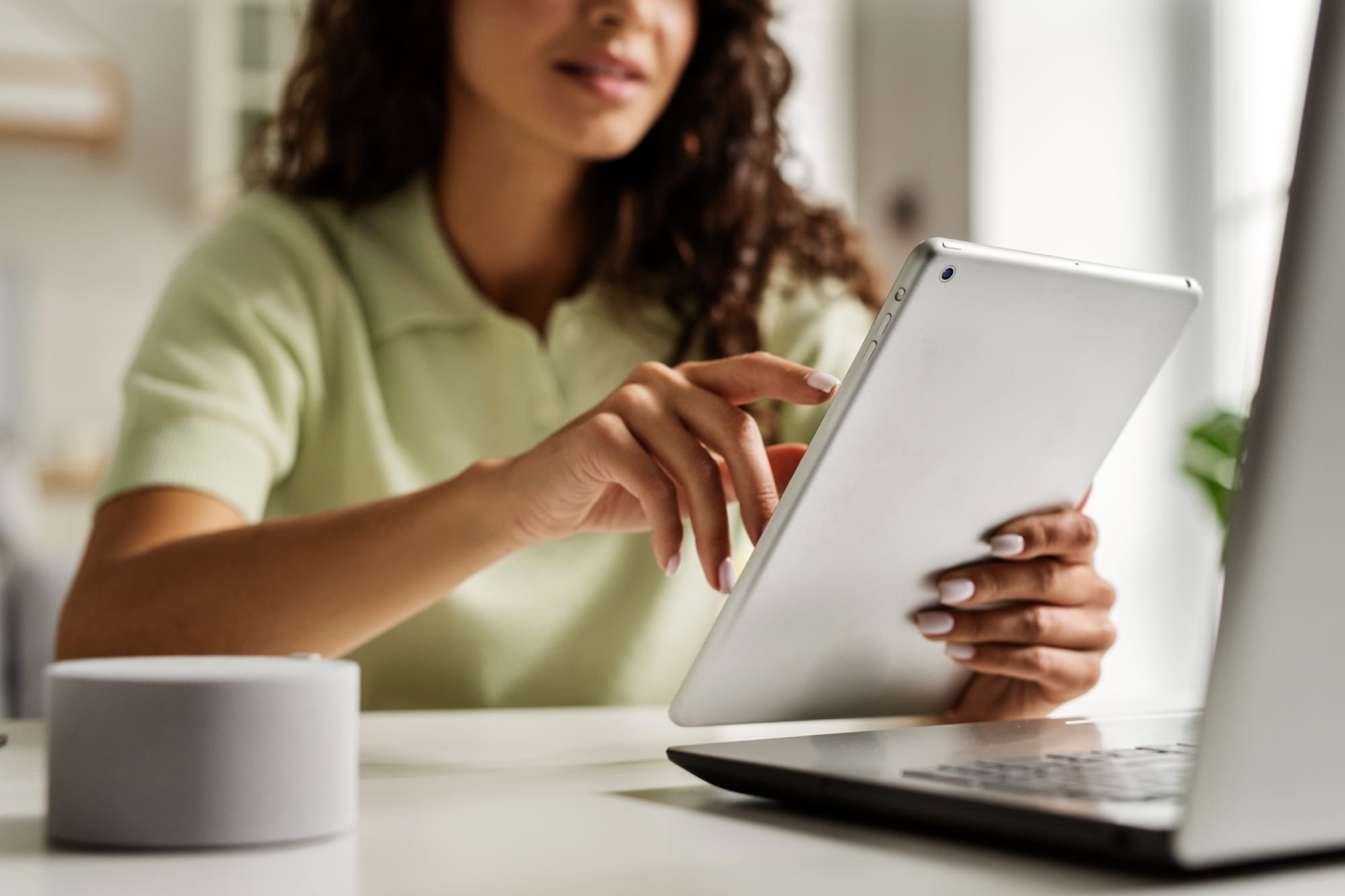 A woman reading iPad and sit near laptop