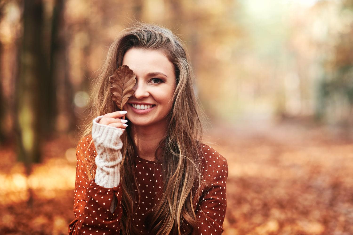 A smiling woman with live in hand in autumn time