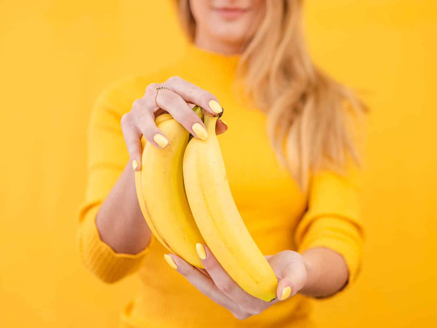 Yellow woman with banana in hands