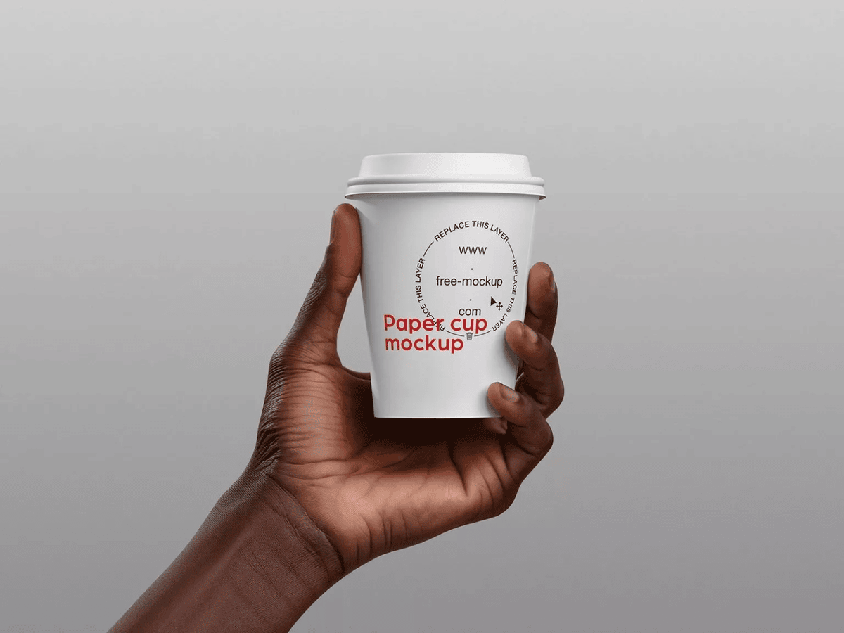 A free paper cup holding in hand mockup
