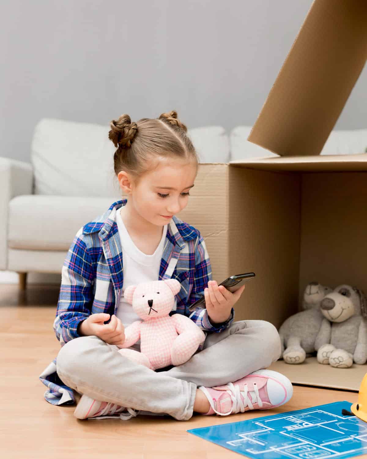 Young girl with a bear toy an d mobile phone